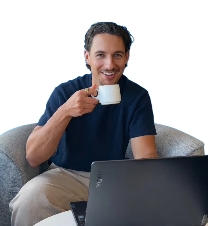 Jack smiling with a coffee at his laptop